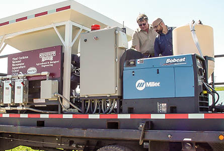 Wise and Pomerleau discuss the general operation of the vaccine delivery system which is a state-of-the-art mechanism that NWAC has in their array of tools that help farmers remain profitable while at the same time assist the researchers in furthering their studies. Photo by Kenner Patton.