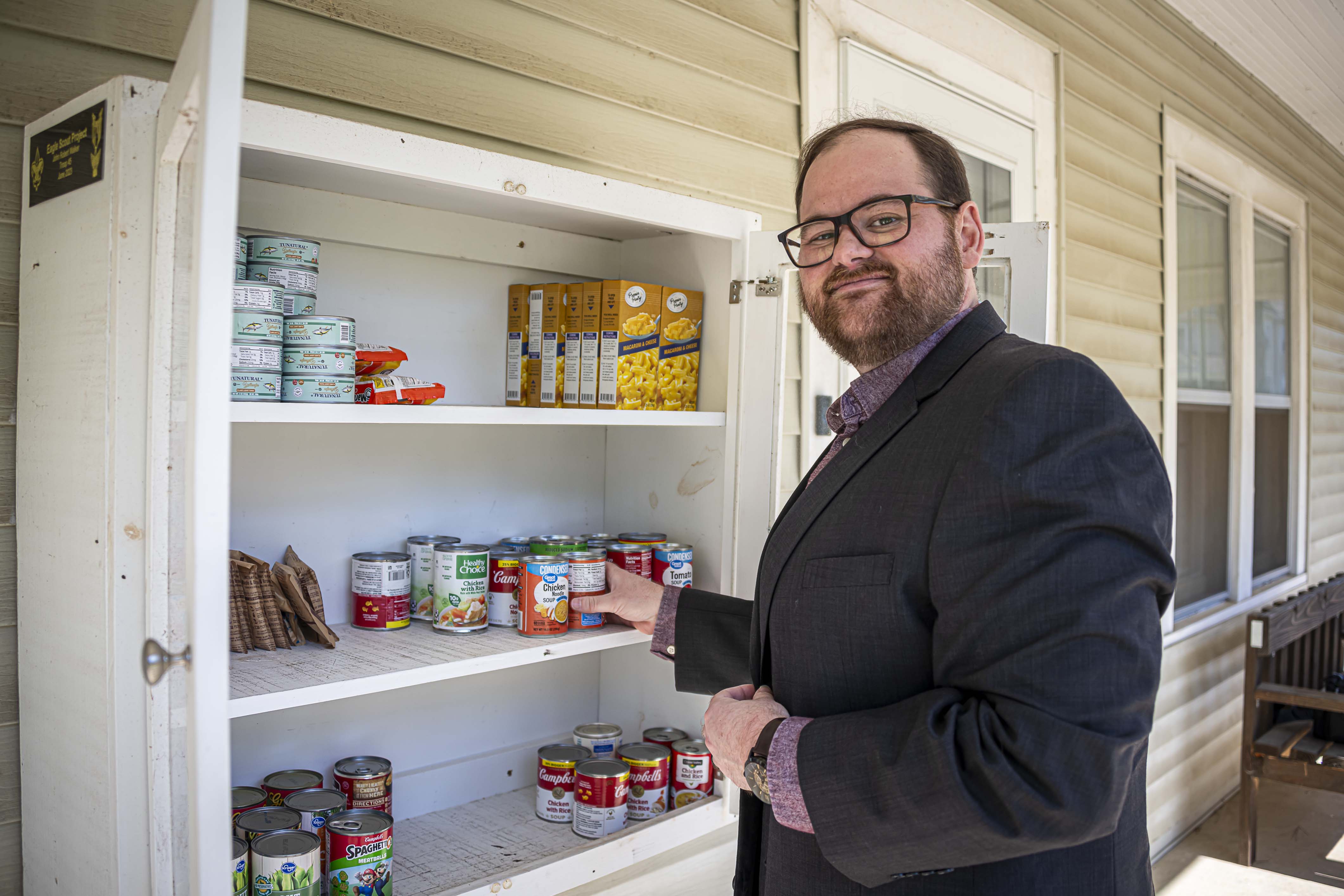 Dr. Will Davis adds food to the outdoor food pantry box at MSU