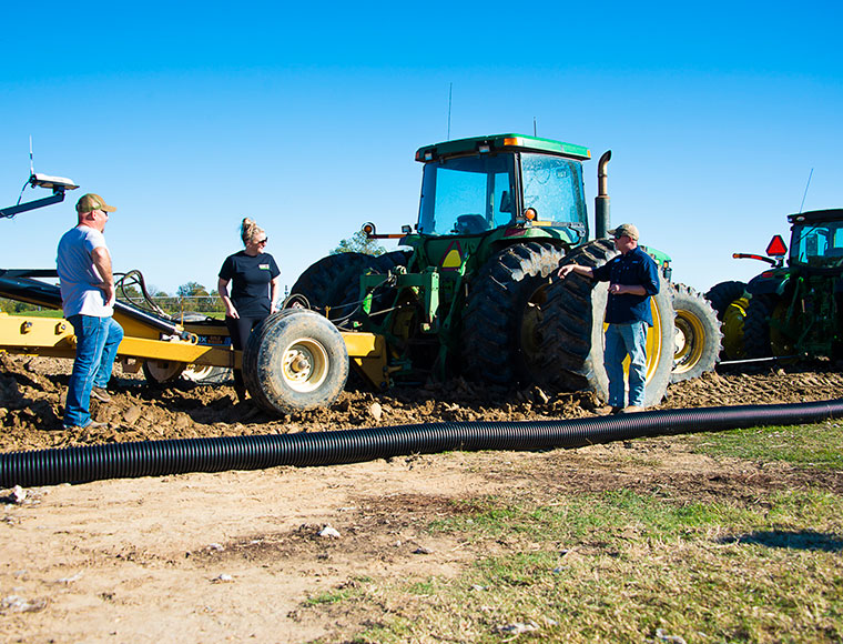 Darrin Dodds, Darla Huff, and Jason Krutz discuss installation of tile drainage as preparations are made to install the main line at Mississippi State