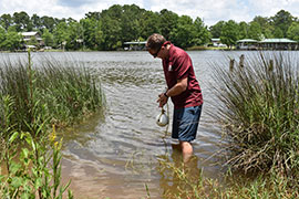 student standing in water with wave sensor