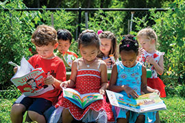 Children sitting at table reading