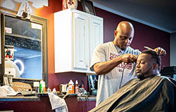barber with patron in chair getting a haircut
