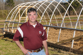 scientist standing in front of high hoop house