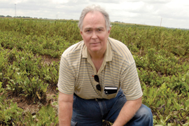 scientist kneeling in field