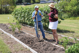 scientist discuss gardening in front of raised bed containers
